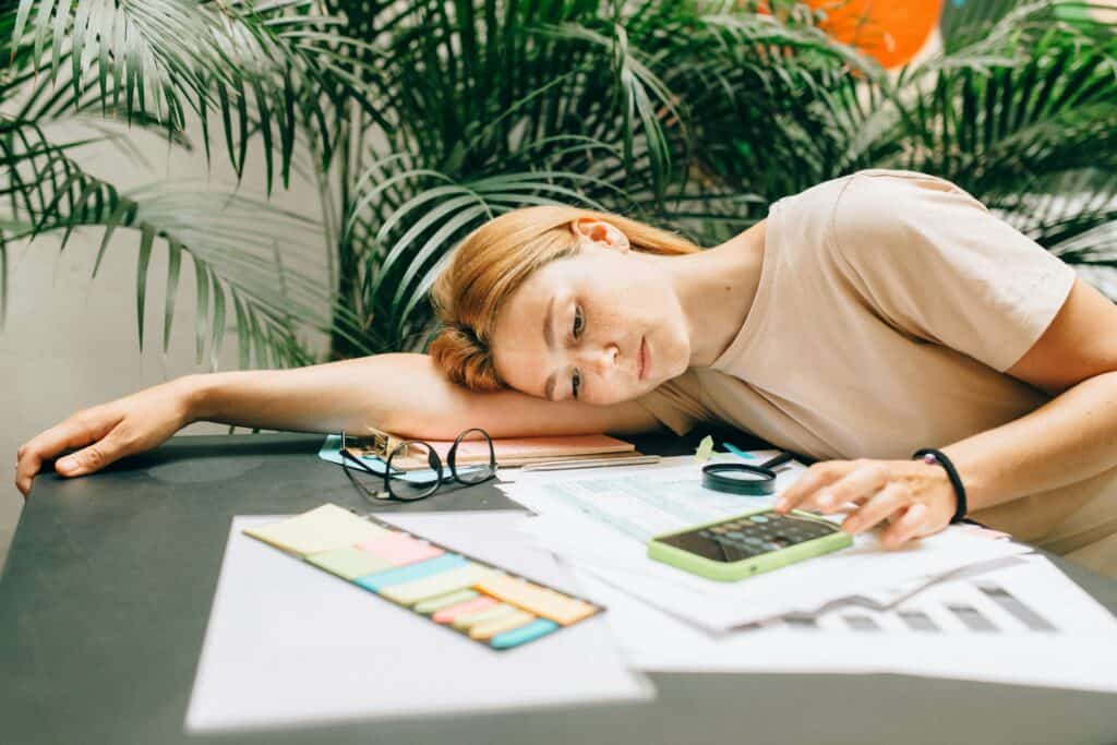 Girl laying down on the table computing taxes