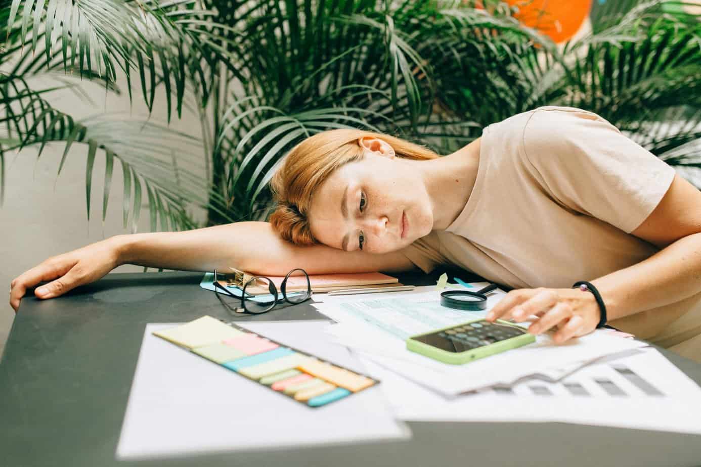 Girl laying down on the table computing taxes